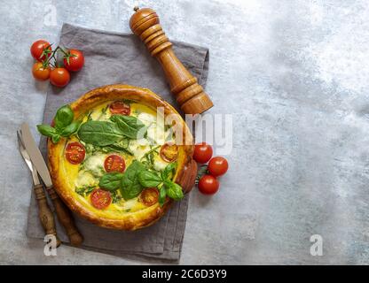 Vegetarian spinach pie or quiche with feta and mozzarella cheese with tomatoes.  Stock Photo