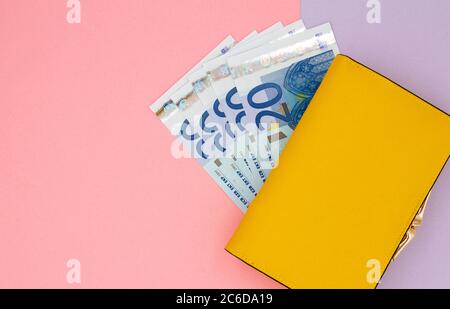 Close-up of yellow wallet with 20 Euro banknotes on a colored background Stock Photo