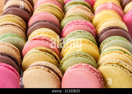 Different colorful french macaroons in a rows. Selective focus. Stock Photo