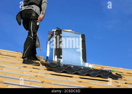 Roofer working on exterior chimney cladding Stock Photo