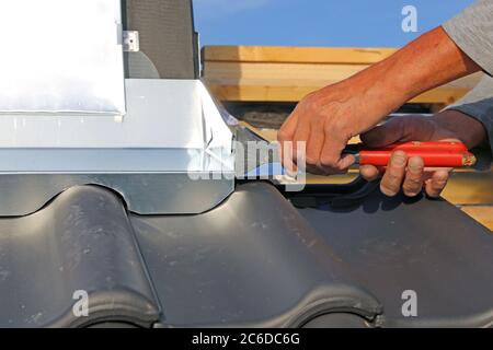Roofer working on exterior chimney cladding Stock Photo