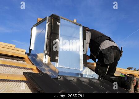 Roofer working on exterior chimney cladding Stock Photo