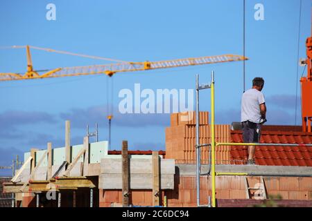 Construction worker (bricklayer) works on the construction site Stock Photo