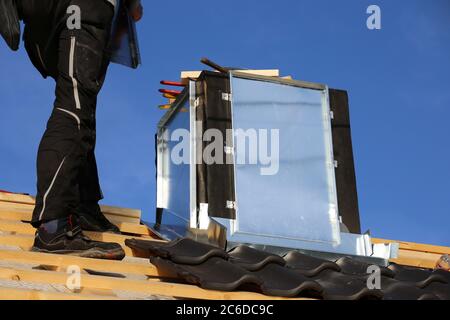 Roofer working on exterior chimney cladding Stock Photo