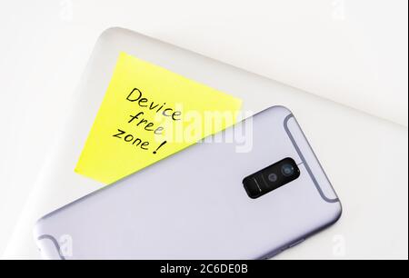 '' Device free zone '' written on green sticky note Stock Photo