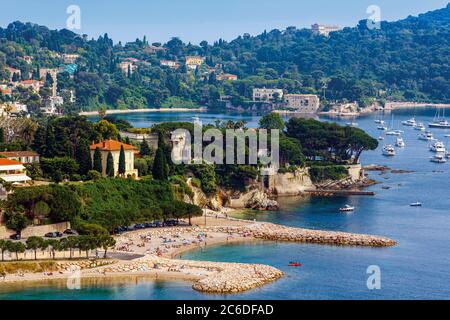 Villafranche-sur-Mer, Cote d'Azur, French Riviera, Alpes-Maritimes, France.  Beach in the harbour and, behind the point, Baie de l'Espalmador Stock Photo