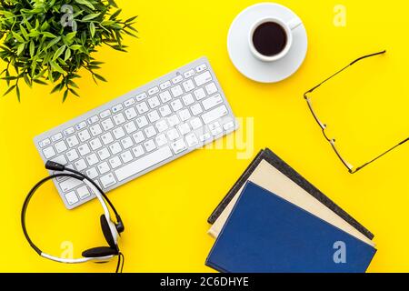 Online education. Books, computer and headphones on yellow background top-down flat lay Stock Photo