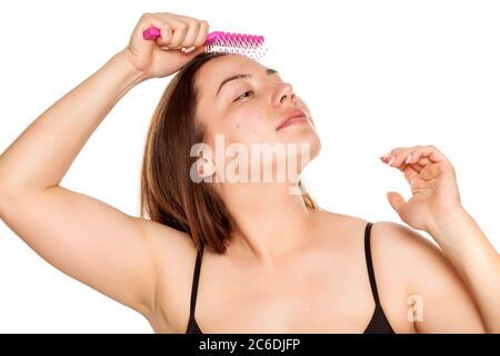 portrait of young woman combing her long hair on white background Stock Photo