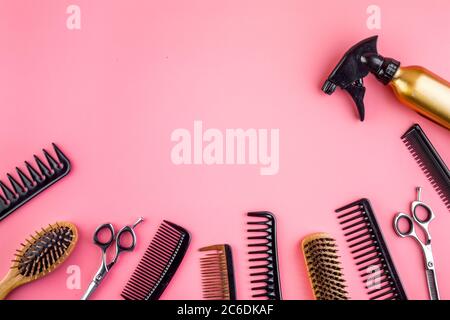 Hairdressing instruments. Combs, scissors and spray on pink desk from above frame space for text Stock Photo