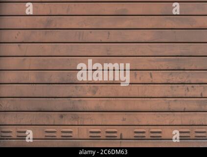 Grungy weathered metallic roll up door. Rusty iron gate. Stock Photo