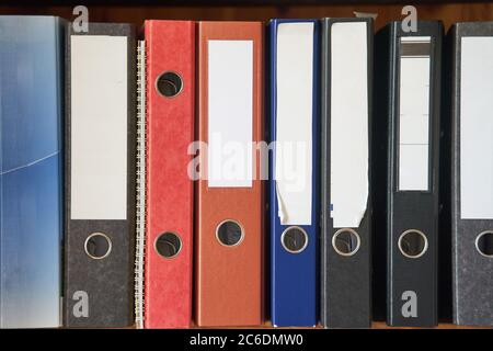 Colored folders for office files and paper on a shelf. Background image Stock Photo