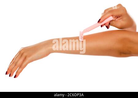 Woman shaves her arm on white background Stock Photo