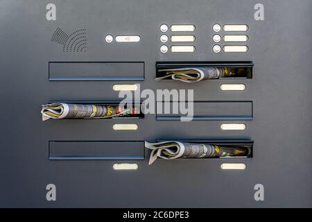 A close up of mailboxes stuffed full with irritating and unwanted advertising mail and brochures Stock Photo