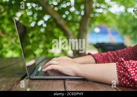 An open laptop stands on a wooden table. Stock Photo
