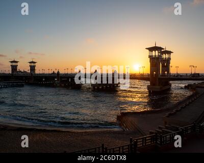 the architectural masterpiece of the stanley bridge and the beach in Alexandria at sunset Stock Photo