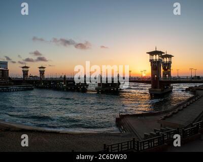 the architectural masterpiece of the stanley bridge with the beach in Alexandria at sunset Stock Photo