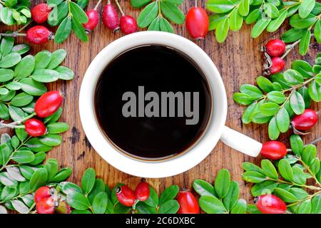 cup of coffee on a wooden board decorated with leaves. Top view. Stock Photo