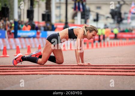 Female British elite runner Hayley Carruthers crawls over the finish line at Virgin Money London Marathon 2019, England, UK Stock Photo