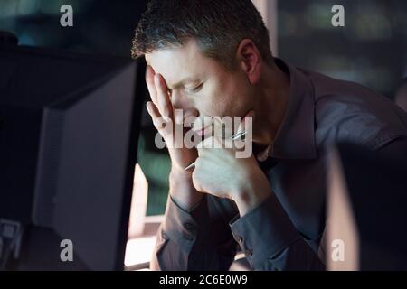 Tired businessman working late at computer Stock Photo