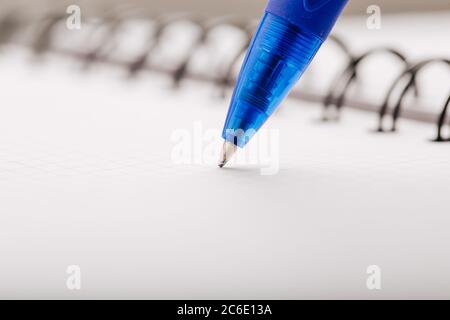 Opened notepad in a cage with an automatic plastic ballpoint pen close-up. Stock Photo