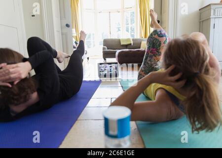 Mother and daughter taking online yoga class at home Stock Photo