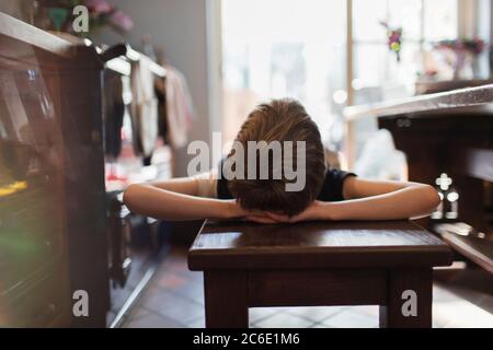 Boy relaxing on bench in kitchen Stock Photo