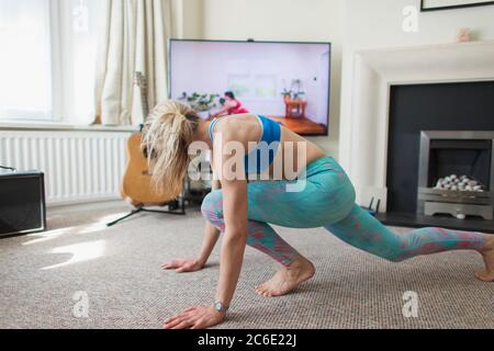 Woman practicing online yoga in living room Stock Photo