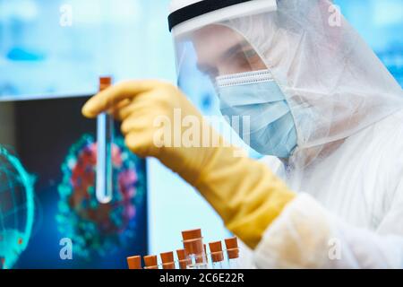 Close up male scientist with test tube studying coronavirus vaccine Stock Photo