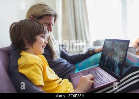 Mother and son using laptop on sofa Stock Photo