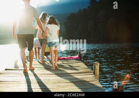 Family walking on dock over lake Stock Photo