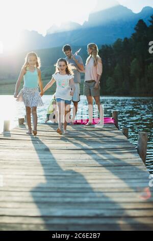 Family walking on dock over lake Stock Photo