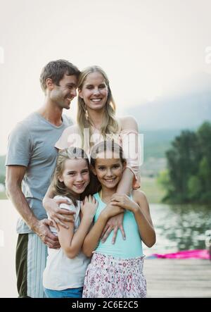 Smiling family on dock over lake Stock Photo
