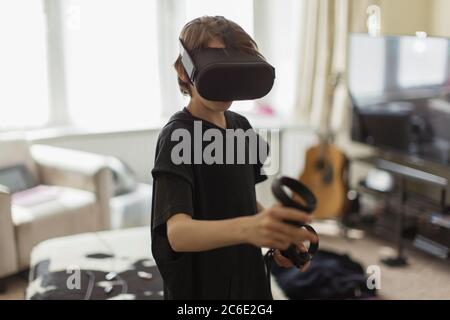 Boy playing video game with VRS goggles Stock Photo