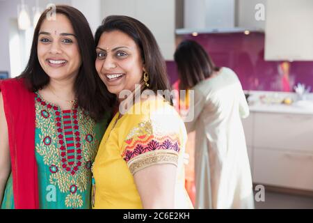 Portrait happy Indian women in saris in kitchen Stock Photo