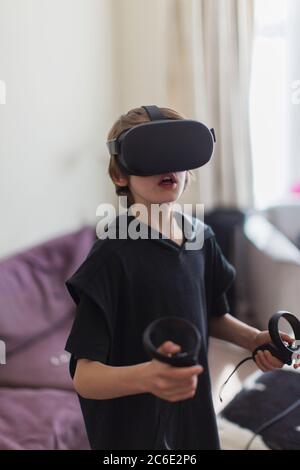 Boy playing video game with VRS goggles Stock Photo