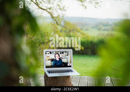 Colleagues video chatting on laptop screen on balcony Stock Photo