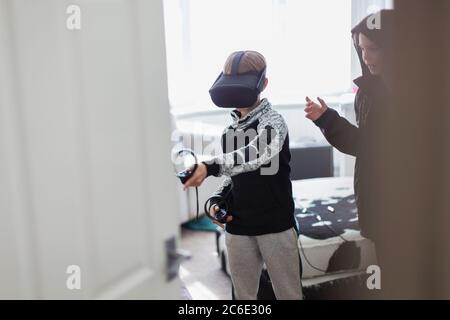 Brothers playing video game with VRS goggles Stock Photo