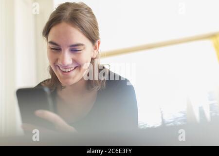 Happy teenage girl using smart phone