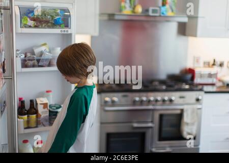 Boy looking inside kitchen refrigerator Stock Photo