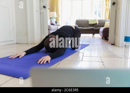 Woman practicing yoga online at home Stock Photo