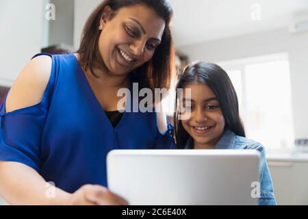 Happy mother and daughter using digital tablet Stock Photo