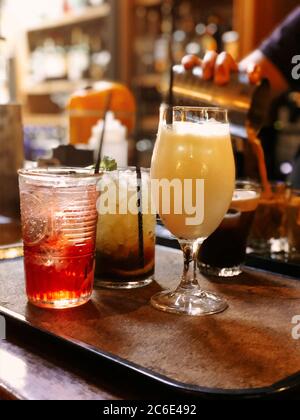 Set of assorted alcohol beverages in glasses placed on tray on counter in pub Stock Photo
