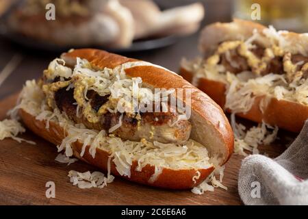 Closeup of grilled bratwurst with sauerkraut and dijon mustard on a bun Stock Photo