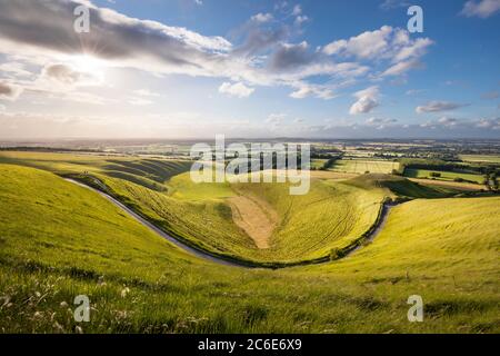 The Manger and Dragon Hill with Vale of White Horse in distance viewed from White Horse Hill at sunset, Uffington, Oxfordshire, England, UK Stock Photo