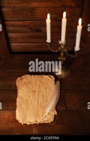 Magical writings, piles, aged paper, candles, wooden brown background Halloween celebration Stock Photo