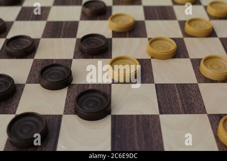 Game of checkers, ancient strategy game consisting of a chessboard and light and dark pawns that challenge each other on it Stock Photo