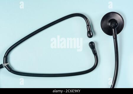 Black stethoscope or phonendoscope on light blue background, Stock Photo
