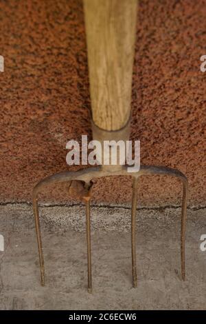 old pitchfork stand on the stone floor. Stock Photo
