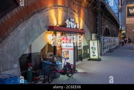 Shimbashi neighborhood old-school alleyways or yokocho filled with tiny eateries, pubs and shops, Tokyo, Japan at dusk. Stock Photo