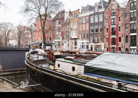 Amsterdam, Netherlands - February 25, 2017: Traditional old living houses and boats are at the canal in Amsterdam Stock Photo